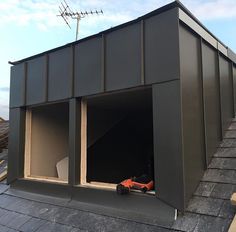 an orange toy car is parked in the open door of a building on top of a roof