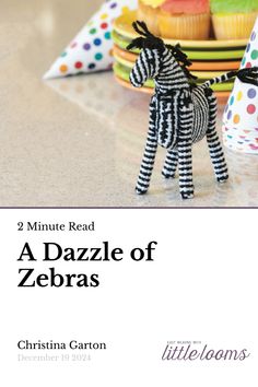 a zebra figurine sitting on top of a table next to cupcakes