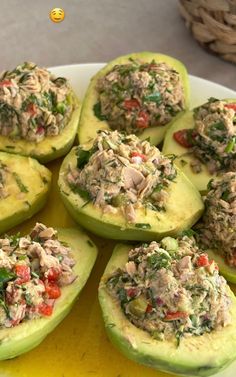 stuffed avocados with tuna and spinach toppings on a white platter