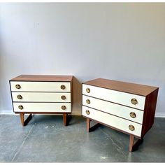 two white and brown dressers sitting next to each other on top of a floor