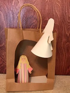 a paper bag with a small doll in it