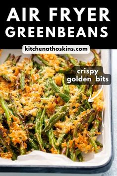 an air fryer filled with green beans and topped with crumby golden bits