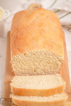 a loaf of white bread sitting on top of a wooden cutting board