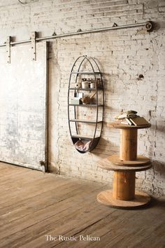 a wooden table sitting in front of a white brick wall next to a metal shelf