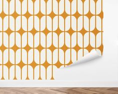 an orange and white wallpaper with circles in the middle on a wooden floor next to a lamp