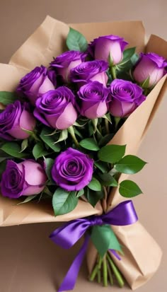 a bouquet of purple roses wrapped in brown paper