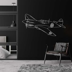 a black wall with an airplane drawn on it and a chair in the foreground