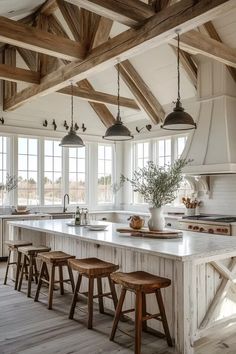 a large kitchen with wooden beams and white counter tops, an island in the middle is surrounded by stools