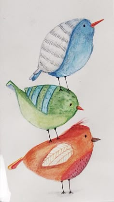 three colorful birds sitting on top of each other