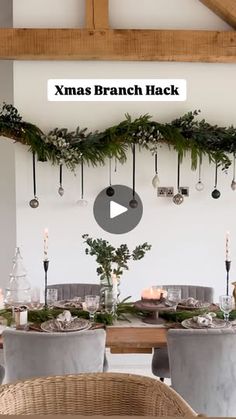 an image of a christmas table setting with candles and greenery on the wall behind it