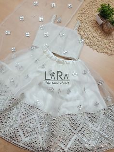 -Beautiful lehenga and choli in pretty ivory white color, is what you need for your little princess to attend the next festive or wedding gathering. -Both top and bottom have cotton and satin linning for comfort. fabric- net work- mirror work -Please go through the size chart before placing the order, or you can text me the custom measurements if required. Feel free to ask any questions on etsy convo. I'll glad to help you out. Care instruction- dry clean only Festive Party Wear Lehenga With Pearl Embroidery, Anarkali Party Sets With Pearl Embroidery, Party Lehenga With Pearl Embroidery In Organza, White Embellished Dresses For Diwali, Off White Sharara With Resham Embroidery For Party, Festive Off White Sets With Pearl Embroidery, White Party Wear Sharara For Eid, White Sharara For Eid Party Wear, Traditional Off White Sharara For Party