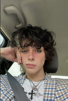 a woman sitting in the back seat of a car with her hand on her head