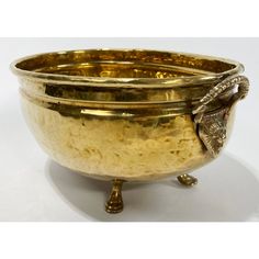 a golden bowl with an elephant head on it