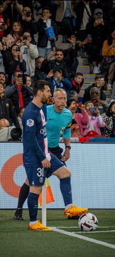 two men are playing soccer in front of an audience