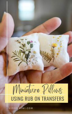 two miniature pillows with flowers on them in the palm of someone's hand and text overlay that reads miniature pillows using rub on transferers