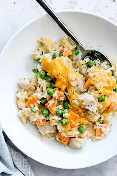 a white bowl filled with chicken and rice casserole on top of a table