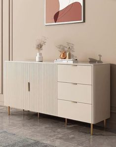 a white and gold sideboard with two vases sitting on it's sides