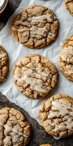 iced cookies with icing sitting on top of a piece of wax paper next to a cup of coffee