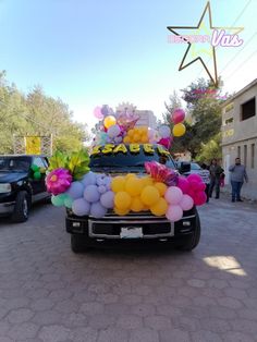 a truck with balloons and streamers on the bed is parked in a parking lot