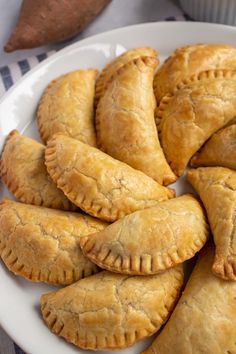 baked empanadas with sweet potato and black beans are on a white plate