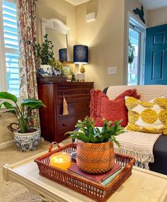 a living room filled with furniture and a plant on top of a wooden coffee table