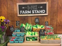 an assortment of vegetables and fruits on display at a farmer's market with signs above them