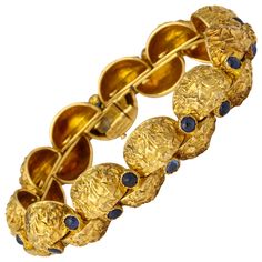 A modern and unusual 1970s bracelet from Cartier-Paris with deeply textured finish on quarter round segments of 18K gold each set with a cabochon sapphire and hinged to move independently and comfortably around the wrist. Measuring 7 1/2 inches long. Weighing 69.2 grams. Cartier mark and gold marks. High Jewelry Bracelet, Octopus Bracelet, Cartier Gold, Cartier Bracelet, Gold Link Bracelet, Antique Bracelets, Cartier Jewelry, Vintage Style Jewellery, Sapphire Bracelet