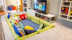 a living room filled with furniture and a flat screen tv sitting on top of a book shelf