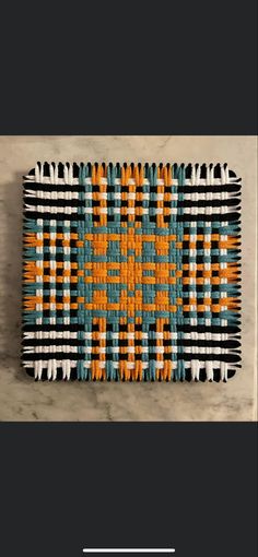 an orange, blue and white rug on top of a wooden table with text overlay