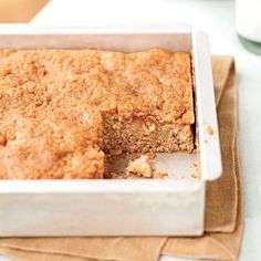 a close up of a cake in a pan on a table with a piece missing