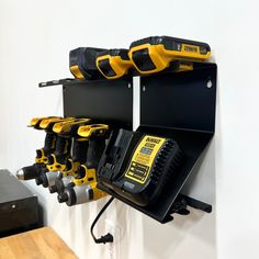 there are many tools hanging on the wall with one cordless drill and two electric screwdrivers