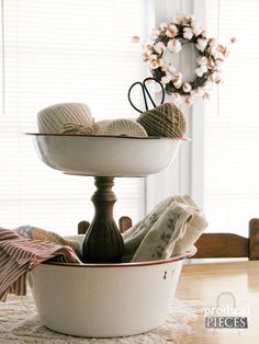 two bowls with yarn and crochet are stacked on top of each other in front of a window