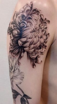 a black and white flower tattoo on the arm