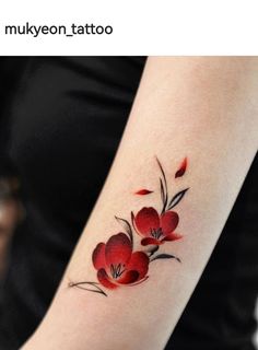 a woman's arm with red flowers and leaves tattoo on the left side of her arm