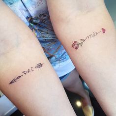 two girls with matching tattoos on their arms, one has an arrow and the other has a rose