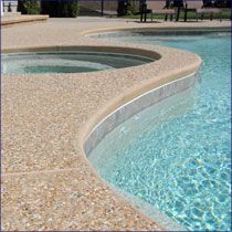 an empty swimming pool with blue water and rocks around the edge is pictured in this image