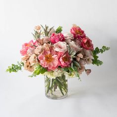 a vase filled with lots of pink and white flowers