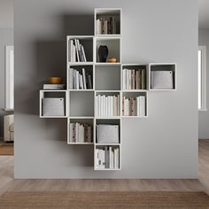 a bookshelf filled with lots of books on top of a hard wood floor