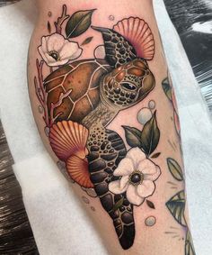 a turtle with shells and flowers on it's leg is shown in this tattoo design