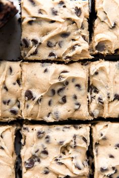 chocolate chip brownies cut into squares on top of each other with frosting in the middle