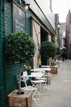 tables and chairs are lined up on the sidewalk