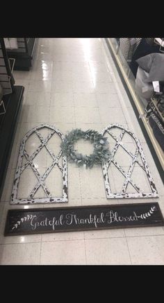 a sign that is sitting on the ground in front of a store floor with wreaths