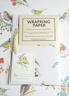 the wrapping paper has birds on it and is next to an envelope that says wrapping paper