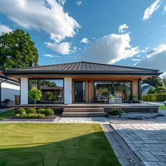 a modern house with an outdoor patio and landscaping