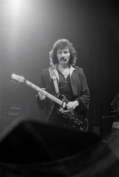 a black and white photo of a man playing an electric guitar