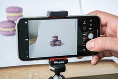 a person taking a photo of some macaroni and cheese cookies on a tripod