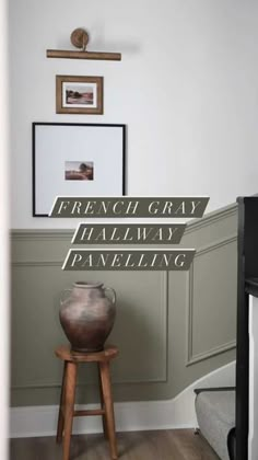 a vase sitting on top of a wooden stool in front of a wall with the words french gray halfway paneling