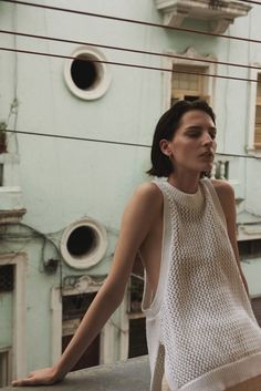 a woman standing on top of a roof next to a building