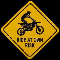 a yellow and black sign that says ride at own, with a dirt bike rider on it