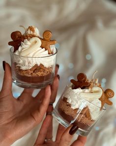 two people are holding small desserts in glass cups with toppings on each one